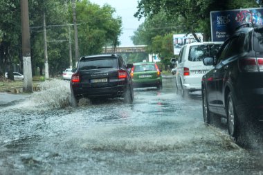 Odessa, Ukrayna -9 Ağustos 2019: sağanak yağışların neden olduğu sel felaketi sırasında su lar altında kalan yolda araba sürmek. Arabalar su üzerinde yüzüyor, sokakları su basayor. Arabaya sıçrat. Büyük bir su birikintisi ile sular altında şehir yolu