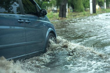 Odessa, Ukrayna -9 Ağustos 2019: sağanak yağışların neden olduğu sel felaketi sırasında su lar altında kalan yolda araba sürmek. Arabalar su üzerinde yüzüyor, sokakları su basayor. Arabaya sıçrat. Büyük bir su birikintisi ile sular altında şehir yolu