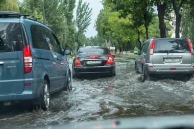 Odessa, Ukrayna -9 Ağustos 2019: sağanak yağışların neden olduğu sel felaketi sırasında su lar altında kalan yolda araba sürmek. Arabalar su üzerinde yüzüyor, sokakları su basayor. Arabaya sıçrat. Büyük bir su birikintisi ile sular altında şehir yolu