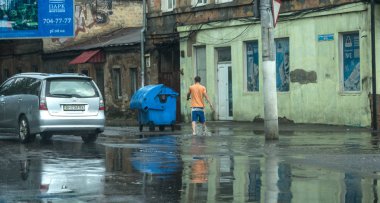Odessa, Ukrayna -9 Ağustos 2019: sağanak yağışların neden olduğu sel felaketi sırasında su lar altında kalan yolda araba sürmek. Arabalar su üzerinde yüzüyor, sokakları su basayor. Arabaya sıçrat. Büyük bir su birikintisi ile sular altında şehir yolu