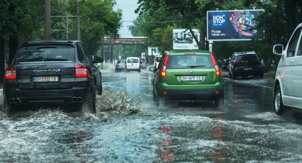 Odessa, Ukrayna -9 Ağustos 2019: sağanak yağışların neden olduğu sel felaketi sırasında su lar altında kalan yolda araba sürmek. Arabalar su üzerinde yüzüyor, sokakları su basayor. Arabaya sıçrat. Büyük bir su birikintisi ile sular altında şehir yolu