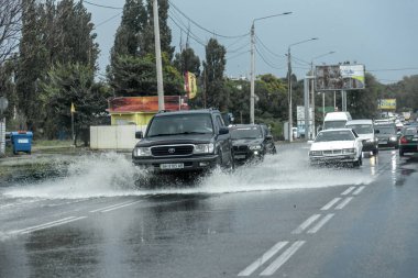 Odessa, Ukrayna - 9 Ağustos 2019: sağanak yağışların neden olduğu sel felaketi sırasında su lar altında kalan yolda araba sürmek. Arabalar su üzerinde yüzüyor, sokakları su basayor. Arabaya sıçrat. Büyük bir su birikintisi ile sular altında şehir yolu