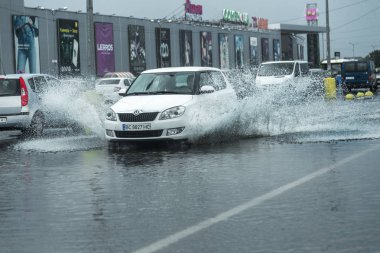 Odessa, Ukrayna - 9 Ağustos 2019: sağanak yağışların neden olduğu sel felaketi sırasında su lar altında kalan yolda araba sürmek. Arabalar su üzerinde yüzüyor, sokakları su basayor. Arabaya sıçrat. Büyük bir su birikintisi ile sular altında şehir yolu