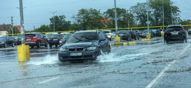 Odessa, Ukrayna - 9 Ağustos 2019: sağanak yağışların neden olduğu sel felaketi sırasında su lar altında kalan yolda araba sürmek. Arabalar su üzerinde yüzüyor, sokakları su basayor. Arabaya sıçrat. Büyük bir su birikintisi ile sular altında şehir yolu