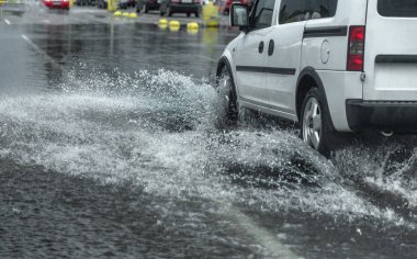 Odessa, Ukrayna - 9 Ağustos 2019: sağanak yağışların neden olduğu sel felaketi sırasında su lar altında kalan yolda araba sürmek. Arabalar su üzerinde yüzüyor, sokakları su basayor. Arabaya sıçrat. Büyük bir su birikintisi ile sular altında şehir yolu