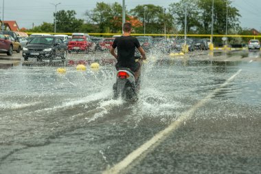Odessa, Ukrayna - 9 Ağustos 2019: sağanak yağışların neden olduğu sel felaketi sırasında su lar altında kalan yolda araba sürmek. Arabalar su üzerinde yüzüyor, sokakları su basayor. Arabaya sıçrat. Büyük bir su birikintisi ile sular altında şehir yolu