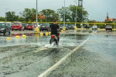 Odessa, Ukrayna - 9 Ağustos 2019: sağanak yağışların neden olduğu sel felaketi sırasında su lar altında kalan yolda araba sürmek. Arabalar su üzerinde yüzüyor, sokakları su basayor. Arabaya sıçrat. Büyük bir su birikintisi ile sular altında şehir yolu