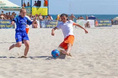 Odessa, Ukrayna-Temmuz 21, 2019: Plajda amatör kadınlar arasında Plaj Futbolu Şampiyonası. Kumda futbol. Genç güzel kızlar şehir plajı kum üzerinde plaj futbol oynarken. Kumüzerinde futbol