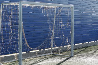 Futbol için eski kapı. Yırtık ızgaralı futbol kapısı. Futbol için gol şeklinde spor ekipmanları. Karanlık atmosferile kale arkası
