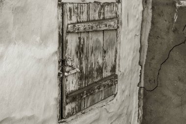 Eski bir şehir duvarında tek ahşap kapı. Kilitli kapalı vintage ahşap kapı. Eski boya ile soyulur eski kapının dokusu,