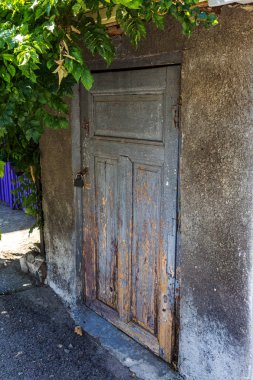 Eski bir şehir duvarında tek ahşap kapı. Kilitli kapalı vintage ahşap kapı. Eski boya ile soyulur eski kapının dokusu,