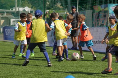 Odessa, Ukrayna - 7 Eylül 2019: Antrenmanda küçük çocuklar futbol oynuyor. Genç çocuklar oyun alanında futbol uyguluyorlar. Çocuklar yeşil futsal sahada futbol oynuyor