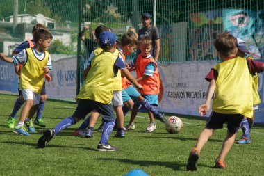 Odessa, Ukrayna - 7 Eylül 2019: Antrenmanda küçük çocuklar futbol oynuyor. Genç çocuklar oyun alanında futbol uyguluyorlar. Çocuklar yeşil futsal sahada futbol oynuyor