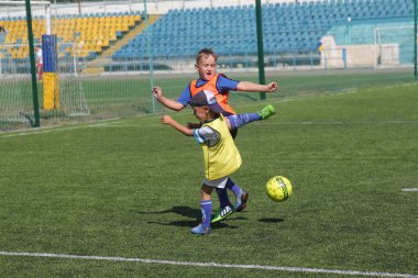 Odessa, Ukrayna - 7 Eylül 2019: Antrenmanda küçük çocuklar futbol oynuyor. Genç çocuklar oyun alanında futbol uyguluyorlar. Çocuklar yeşil futsal sahada futbol oynuyor