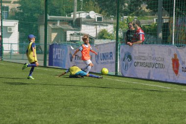 Odessa, Ukrayna - 7 Eylül 2019: Antrenmanda küçük çocuklar futbol oynuyor. Genç çocuklar oyun alanında futbol uyguluyorlar. Çocuklar yeşil futsal sahada futbol oynuyor