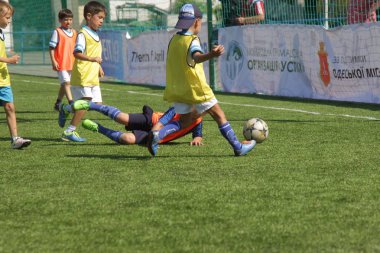 Odessa, Ukrayna - 7 Eylül 2019: Antrenmanda küçük çocuklar futbol oynuyor. Genç çocuklar oyun alanında futbol uyguluyorlar. Çocuklar yeşil futsal sahada futbol oynuyor