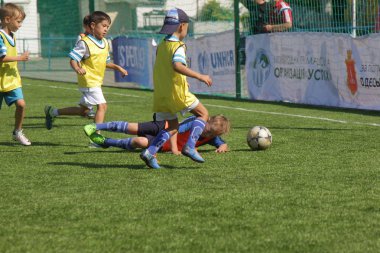 Odessa, Ukrayna - 7 Eylül 2019: Antrenmanda küçük çocuklar futbol oynuyor. Genç çocuklar oyun alanında futbol uyguluyorlar. Çocuklar yeşil futsal sahada futbol oynuyor