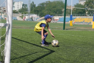 Odessa, Ukrayna - 7 Eylül 2019: Antrenmanda küçük çocuklar futbol oynuyor. Genç çocuklar oyun alanında futbol uyguluyorlar. Çocuklar yeşil futsal sahada futbol oynuyor