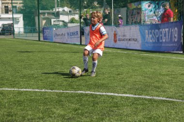 Odessa, Ukrayna - 7 Eylül 2019: Antrenmanda küçük çocuklar futbol oynuyor. Genç çocuklar oyun alanında futbol uyguluyorlar. Çocuklar yeşil futsal sahada futbol oynuyor