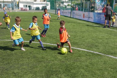Odessa, Ukrayna - 7 Eylül 2019: Antrenmanda küçük çocuklar futbol oynuyor. Genç çocuklar oyun alanında futbol uyguluyorlar. Çocuklar yeşil futsal sahada futbol oynuyor