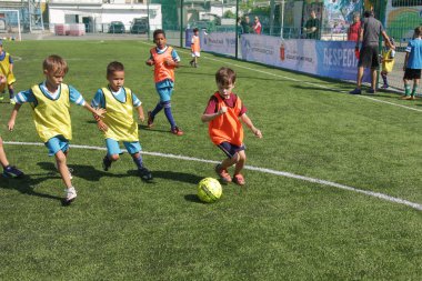 Odessa, Ukrayna - 7 Eylül 2019: Antrenmanda küçük çocuklar futbol oynuyor. Genç çocuklar oyun alanında futbol uyguluyorlar. Çocuklar yeşil futsal sahada futbol oynuyor