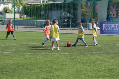 Odessa, Ukrayna - 7 Eylül 2019: Antrenmanda küçük çocuklar futbol oynuyor. Genç çocuklar oyun alanında futbol uyguluyorlar. Çocuklar yeşil futsal sahada futbol oynuyor