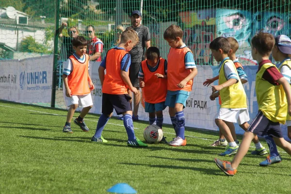 Odessa, Ukrayna - 7 Eylül 2019: Antrenmanda küçük çocuklar futbol oynuyor. Genç çocuklar oyun alanında futbol uyguluyorlar. Çocuklar yeşil futsal sahada futbol oynuyor