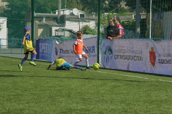 Odessa, Ukrayna - 7 Eylül 2019: Antrenmanda küçük çocuklar futbol oynuyor. Genç çocuklar oyun alanında futbol uyguluyorlar. Çocuklar yeşil futsal sahada futbol oynuyor