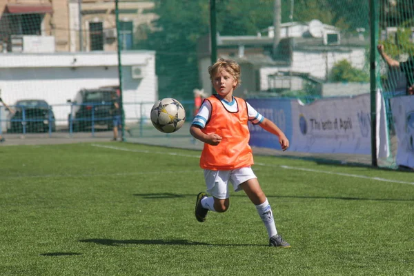 Odessa, Ukrayna - 7 Eylül 2019: Antrenmanda küçük çocuklar futbol oynuyor. Genç çocuklar oyun alanında futbol uyguluyorlar. Çocuklar yeşil futsal sahada futbol oynuyor