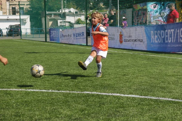 Odessa, Ukrayna - 7 Eylül 2019: Antrenmanda küçük çocuklar futbol oynuyor. Genç çocuklar oyun alanında futbol uyguluyorlar. Çocuklar yeşil futsal sahada futbol oynuyor
