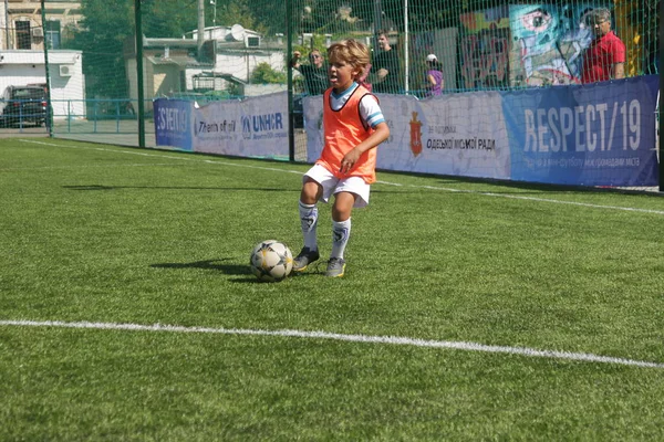 Odessa, Ukrayna - 7 Eylül 2019: Antrenmanda küçük çocuklar futbol oynuyor. Genç çocuklar oyun alanında futbol uyguluyorlar. Çocuklar yeşil futsal sahada futbol oynuyor