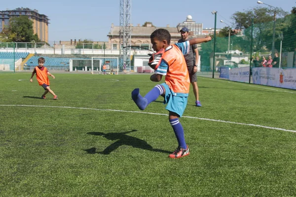 Odessa, Ukrayna - 7 Eylül 2019: Antrenmanda küçük çocuklar futbol oynuyor. Genç çocuklar oyun alanında futbol uyguluyorlar. Çocuklar yeşil futsal sahada futbol oynuyor