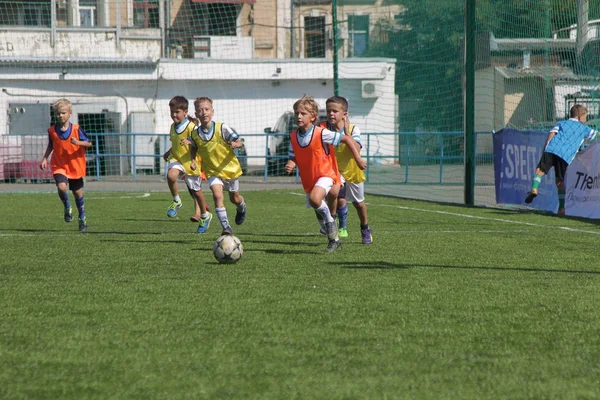 Odessa, Ukrayna - 7 Eylül 2019: Antrenmanda küçük çocuklar futbol oynuyor. Genç çocuklar oyun alanında futbol uyguluyorlar. Çocuklar yeşil futsal sahada futbol oynuyor