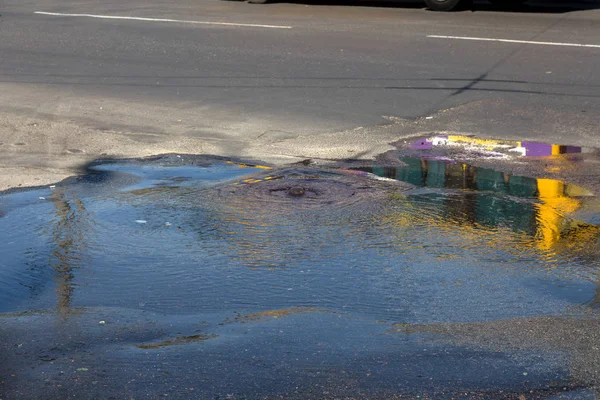 Accident of water supply, sewerage. Water flows from hatch of road sewage system. Dirty sewer flows down fountain along road. Water flows from hatch. Fountain flows down road from sewer — Stock Image Accident Water Supply Sewerage Water Flows Hatch Road Sewage System Stock Photo