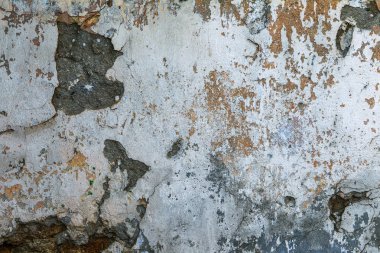 Şablon ve arka plan için güneş ışığındaki eski, dağınık taş ya da beton duvar dokusu. Arka plan olarak çatlamış beton duvar. Seçici odak eski çatlak sıva