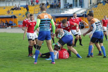 Odessa, Ukrayna - 29 Eylül 2019: Odessa ragbi takımı - Kiev Politeknik. Rugby oyuncularının top için yoğun mücadelesi. Stadyumun yeşil sahasında dinamik bir oyun. Vahşi Rugby Dövüşü