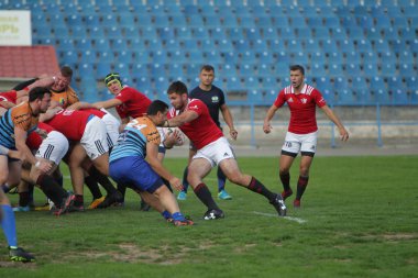 Odessa, Ukrayna - 29 Eylül 2019: Odessa ragbi takımı - Kiev Politeknik. Rugby oyuncularının top için yoğun mücadelesi. Stadyumun yeşil sahasında dinamik bir oyun. Vahşi Rugby Dövüşü