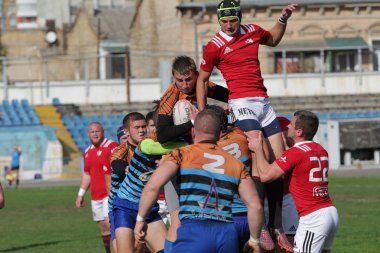 Odessa, Ukrayna - 29 Eylül 2019: Odessa ragbi takımı - Kiev Politeknik. Rugby oyuncularının top için yoğun mücadelesi. Stadyumun yeşil sahasında dinamik bir oyun. Vahşi Rugby Dövüşü