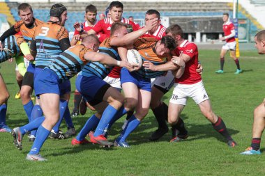 Odessa, Ukrayna - 29 Eylül 2019: Odessa ragbi takımı - Kiev Politeknik. Rugby oyuncularının top için yoğun mücadelesi. Stadyumun yeşil sahasında dinamik bir oyun. Vahşi Rugby Dövüşü