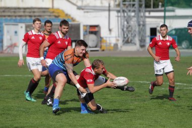 Odessa, Ukrayna - 29 Eylül 2019: Odessa ragbi takımı - Kiev Politeknik. Rugby oyuncularının top için yoğun mücadelesi. Stadyumun yeşil sahasında dinamik bir oyun. Vahşi Rugby Dövüşü