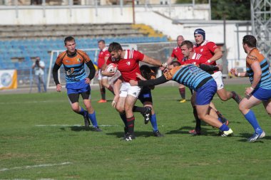 Odessa, Ukrayna - 29 Eylül 2019: Odessa ragbi takımı - Kiev Politeknik. Rugby oyuncularının top için yoğun mücadelesi. Stadyumun yeşil sahasında dinamik bir oyun. Vahşi Rugby Dövüşü