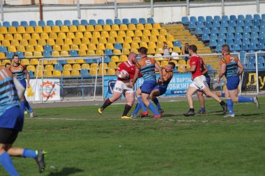 Odessa, Ukrayna - 29 Eylül 2019: Odessa ragbi takımı - Kiev Politeknik. Rugby oyuncularının top için yoğun mücadelesi. Stadyumun yeşil sahasında dinamik bir oyun. Vahşi Rugby Dövüşü