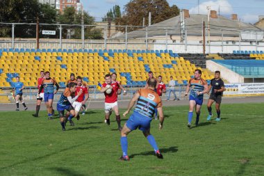 Odessa, Ukrayna - 29 Eylül 2019: Odessa ragbi takımı - Kiev Politeknik. Rugby oyuncularının top için yoğun mücadelesi. Stadyumun yeşil sahasında dinamik bir oyun. Vahşi Rugby Dövüşü