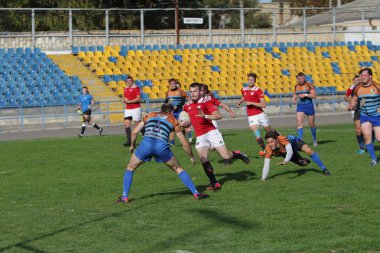 Odessa, Ukrayna - 29 Eylül 2019: Odessa ragbi takımı - Kiev Politeknik. Rugby oyuncularının top için yoğun mücadelesi. Stadyumun yeşil sahasında dinamik bir oyun. Vahşi Rugby Dövüşü
