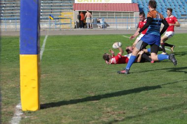 Odessa, Ukrayna - 29 Eylül 2019: Odessa ragbi takımı - Kiev Politeknik. Rugby oyuncularının top için yoğun mücadelesi. Stadyumun yeşil sahasında dinamik bir oyun. Vahşi Rugby Dövüşü