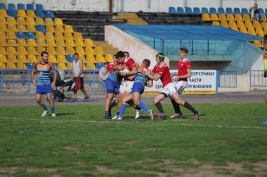 Odessa, Ukrayna - 29 Eylül 2019: Odessa ragbi takımı - Kiev Politeknik. Rugby oyuncularının top için yoğun mücadelesi. Stadyumun yeşil sahasında dinamik bir oyun. Vahşi Rugby Dövüşü