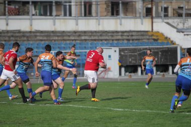 Odessa, Ukrayna - 29 Eylül 2019: Odessa ragbi takımı - Kiev Politeknik. Rugby oyuncularının top için yoğun mücadelesi. Stadyumun yeşil sahasında dinamik bir oyun. Vahşi Rugby Dövüşü