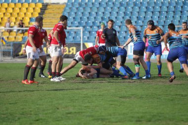 Odessa, Ukrayna - 29 Eylül 2019: Odessa ragbi takımı - Kiev Politeknik. Rugby oyuncularının top için yoğun mücadelesi. Stadyumun yeşil sahasında dinamik bir oyun. Vahşi Rugby Dövüşü