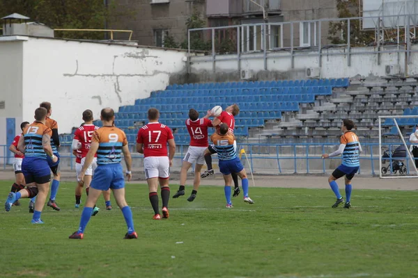 Odessa, Ukrayna - 29 Eylül 2019: Odessa ragbi takımı - Kiev Politeknik. Rugby oyuncularının top için yoğun mücadelesi. Stadyumun yeşil sahasında dinamik bir oyun. Vahşi Rugby Dövüşü