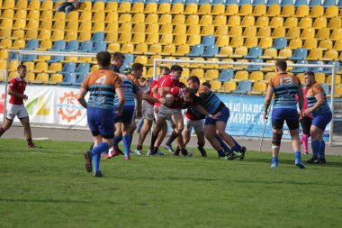 Odessa, Ukrayna - 29 Eylül 2019: Odessa ragbi takımı - Kiev Politeknik. Rugby oyuncularının top için yoğun mücadelesi. Stadyumun yeşil sahasında dinamik bir oyun. Vahşi Rugby Dövüşü